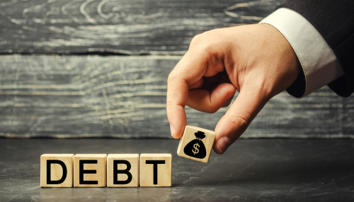 Wooden blocks with the word debt and the image of dollars.