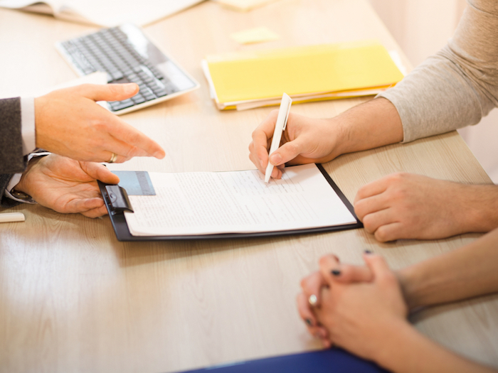 2 people signing a form