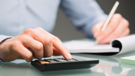 a person using a calculator and writing in a notepad