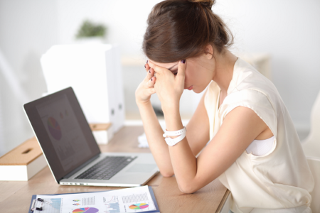 a stressed woman using a laptop