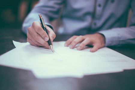 Man signing a PPI claim form.