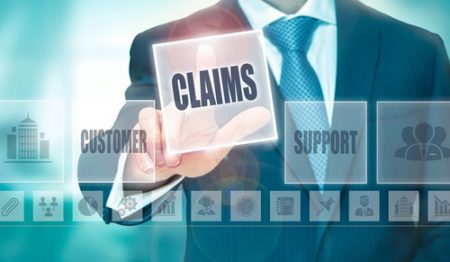 A businessman pressing a Claims button on a transparent screen. a blog about covid-19 claims management.
